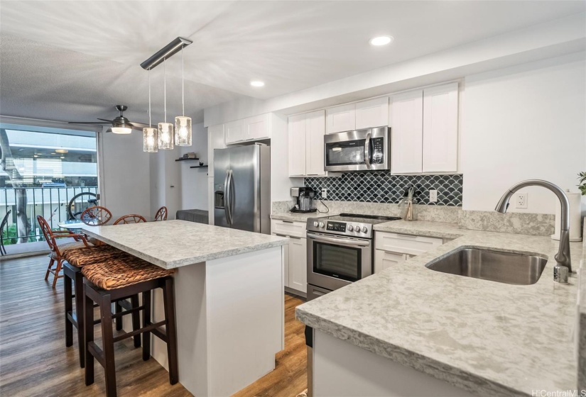 Recently renovated kitchen island with bar stools and dining area