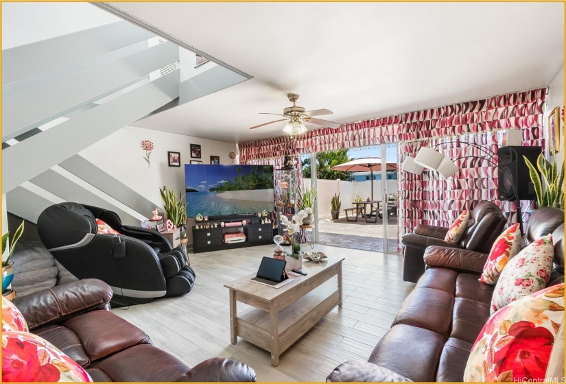 Spacious Downstairs Living Room with View of Stairs and Back Patio