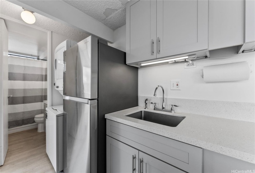 Modern refrigerator and washer/dryer in unit.