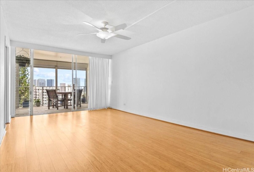 Spacious living area with hardwood bamboo floors and sliding doors that lead to lanai.