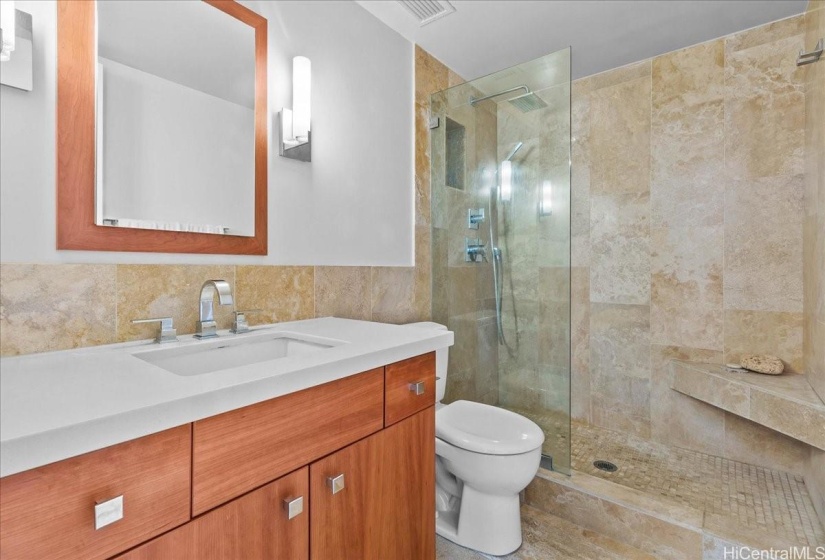 Ensuite primary bathroom completed renovated with luxury travertine tile and Quartz counters on wood vanity