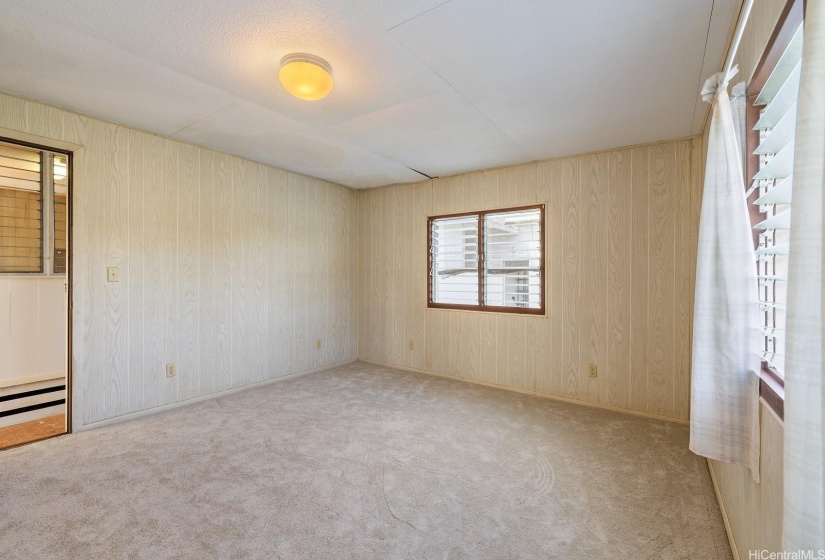 Separate studio room with paneling and new carpet attached to front side of carport.  Could be used as a home office or guest quarters.