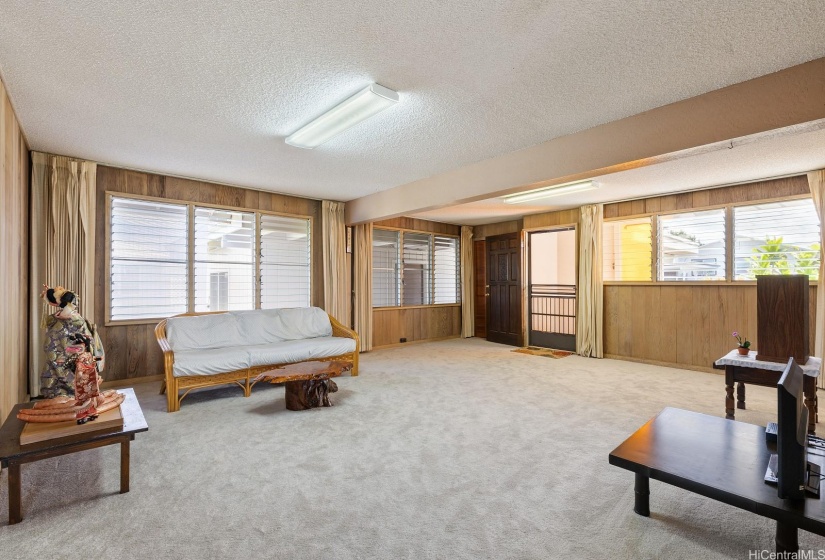 Large living room with new carpets and lots of windows for lighting and breezes to make this a cheerful family home.