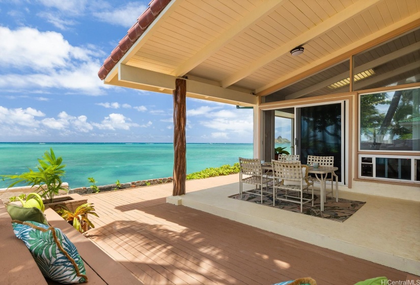 Outdoor lanai off of the sitting room has a covered dining area and built-in bench for enjoying natural air conditioning.