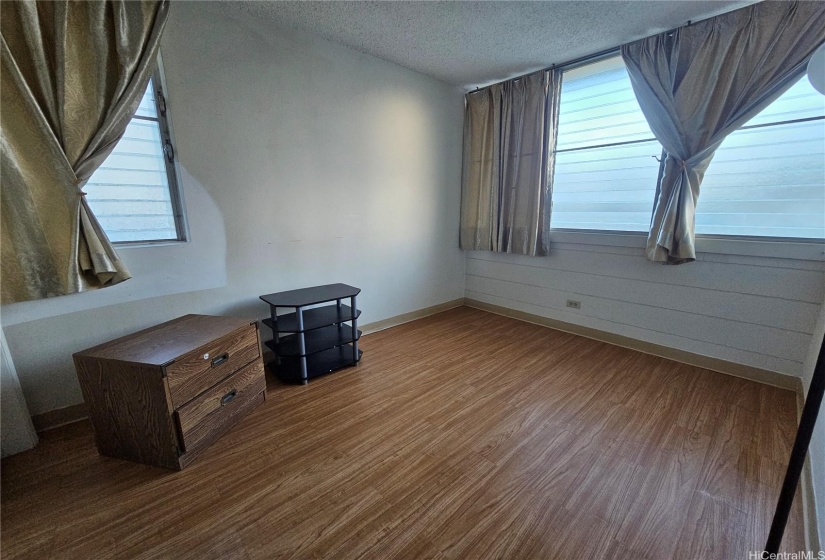 Bedroom 2, corner room with good ventilation. Curtains and storage items removed.