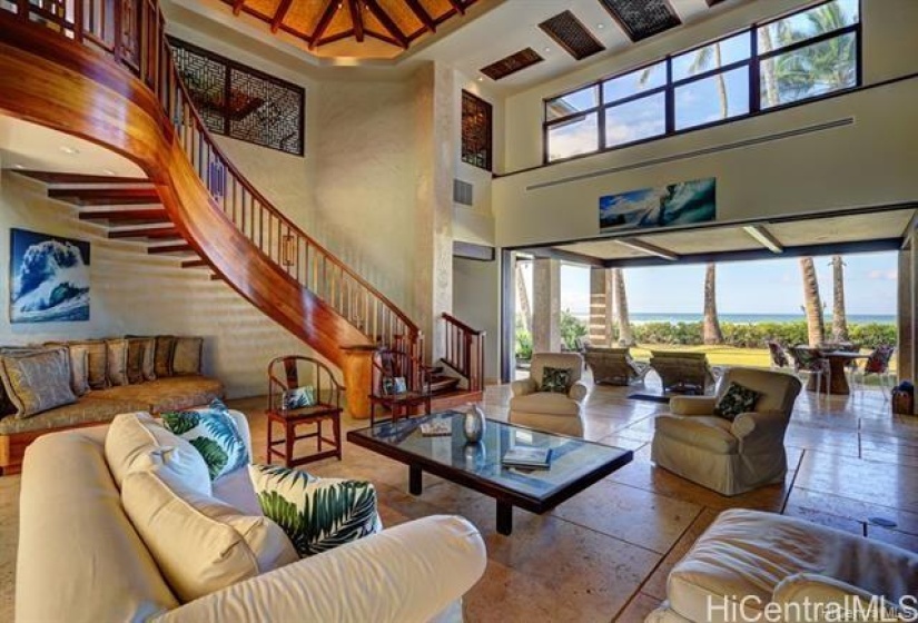 Main dwelling living room. Opens out to Oceanside lanai. Koa staircase leads to upstairs office and Master on Suite with AC