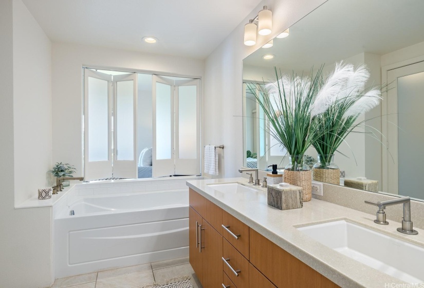 The primary bathroom also has a soaking tub, and just like a high end hotel you can open the window to see into the bedroom.