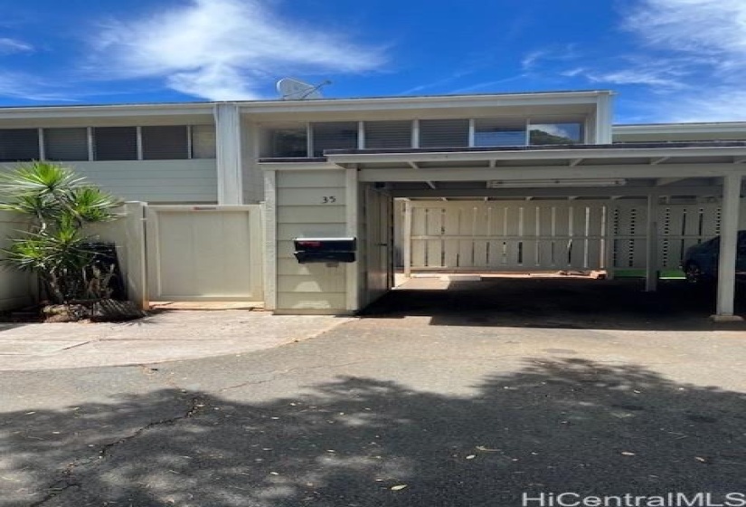 Gated 2 story house with carport and 1-open parking stall.