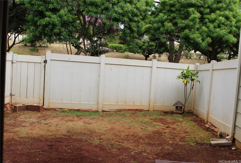 Enclosed backyard waits for the new owner with green thumbs.