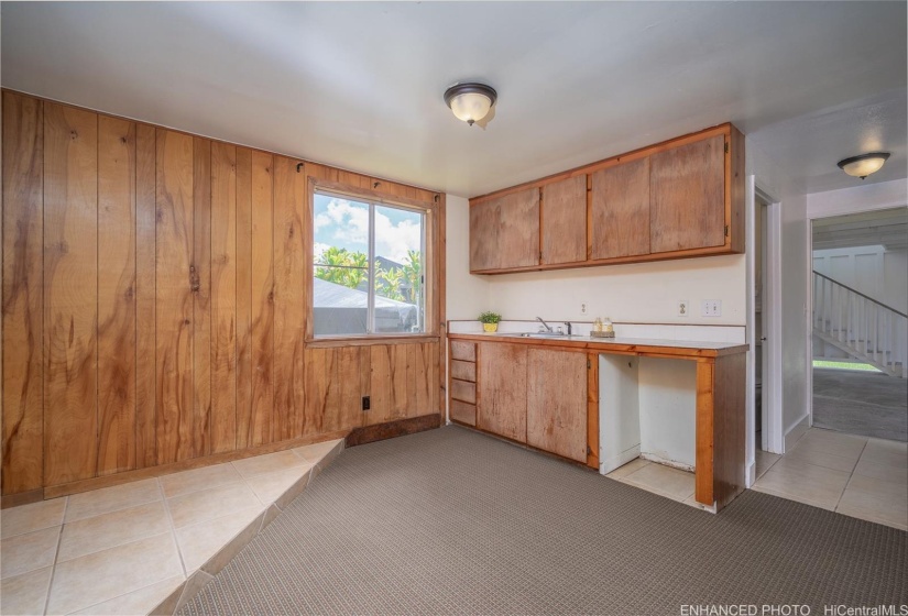 First floor dwelling featuring wet bar and hallway that leads to one bedroom, one full bathroom and garage entry. Enhanced