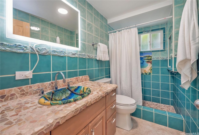 The tile work in the downstairs bathroom was artistically installed to create a relationship with the ocean