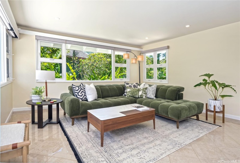 The living area of this lovely home is highlighted by large picture windows that allow the perfect amount of natural lighting accented by a lush variety of greenery surround the property.