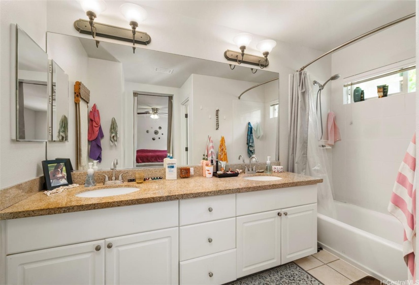 Main bathroom with two sinks and tub.