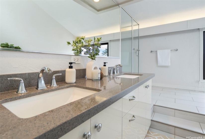 Primary bath has double sinks with quartz countertops and soft-close drawers, tile flooring, walk-in shower.