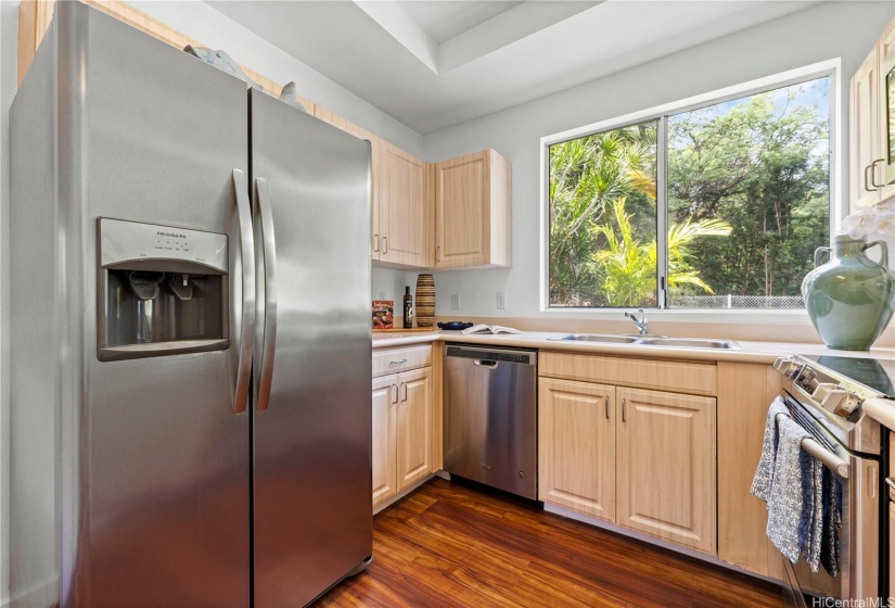 Stainless appliances and a lush view out the window