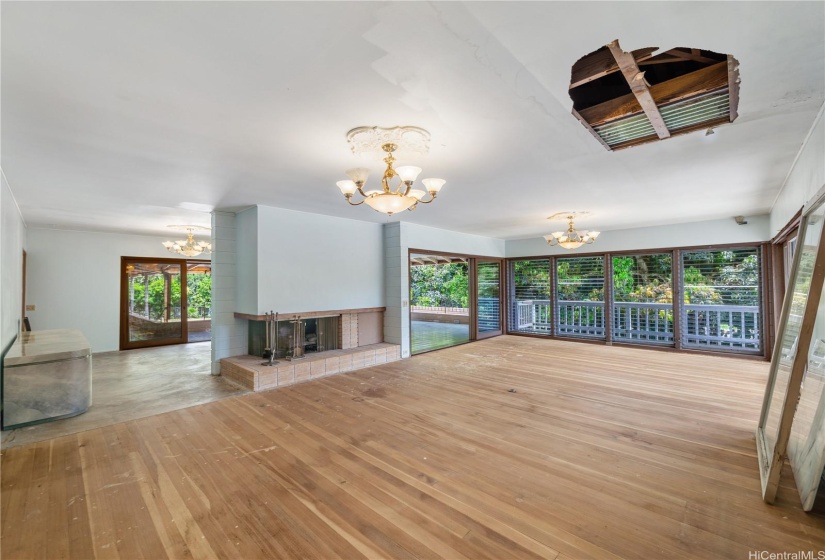 A grand living room, with windows over looking the estate grounds.