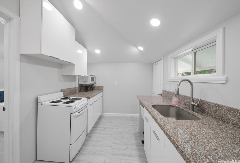 Kitchen remodeled with new acrylic glossy cabs, granite countertops and stainless steel fixtures.