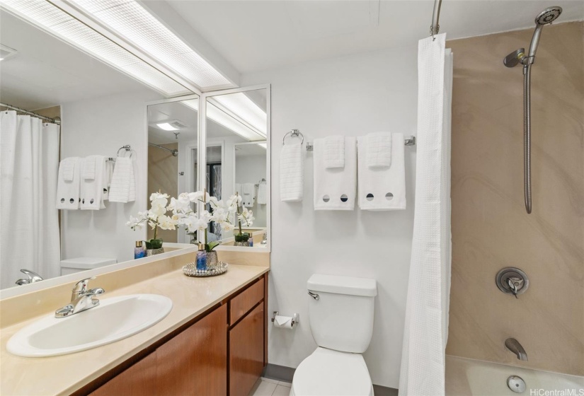 Primary ensuite bath with combination tub and shower as well as refinished solid wood vanity.