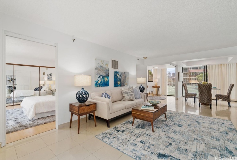 Open floor plan with living room, dining area, and 3rd bedroom with sliding walls that can also be used as a den or home office.  Primary bedroom suite through doorway on the left in the photo.