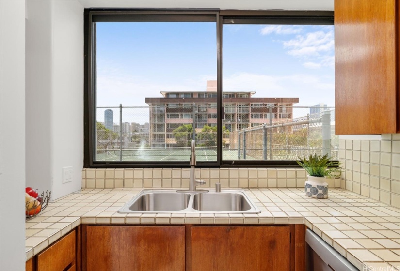 You can also enjoy a view of the tennis court from the kitchen window, which is also a great pass-through for food and drinks to the 800 SF lanai for outdoor dining.