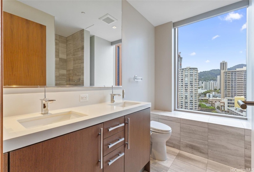 The gorgeous bathroom features twin sinks, a Toto toilet, and a spacious walk in shower.