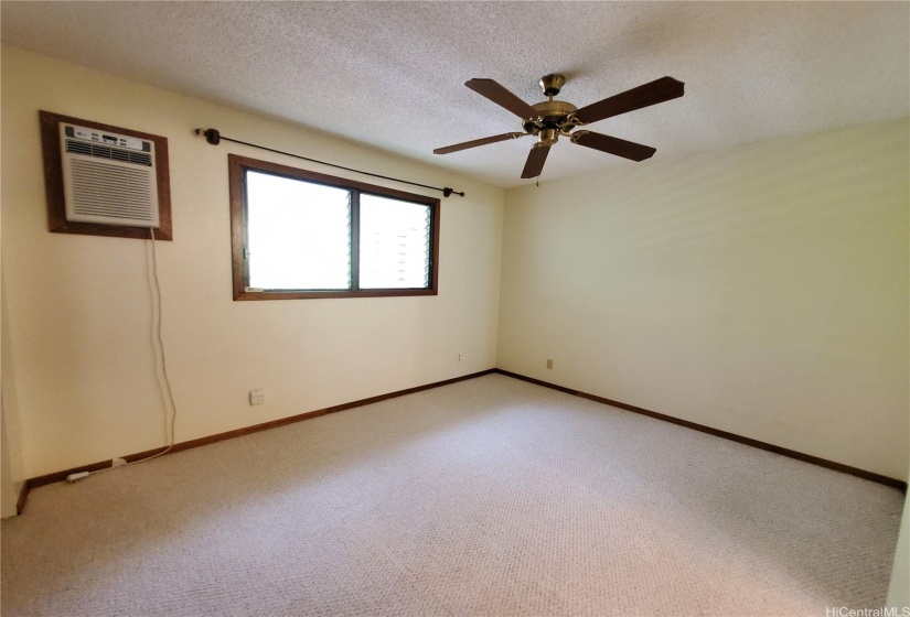 Primary Bedroom with Window A/C Unit and Ceiling Fan