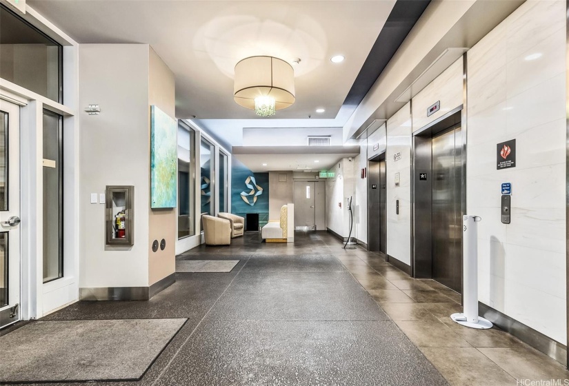 Elegant lobby with sitting area and two elevators.