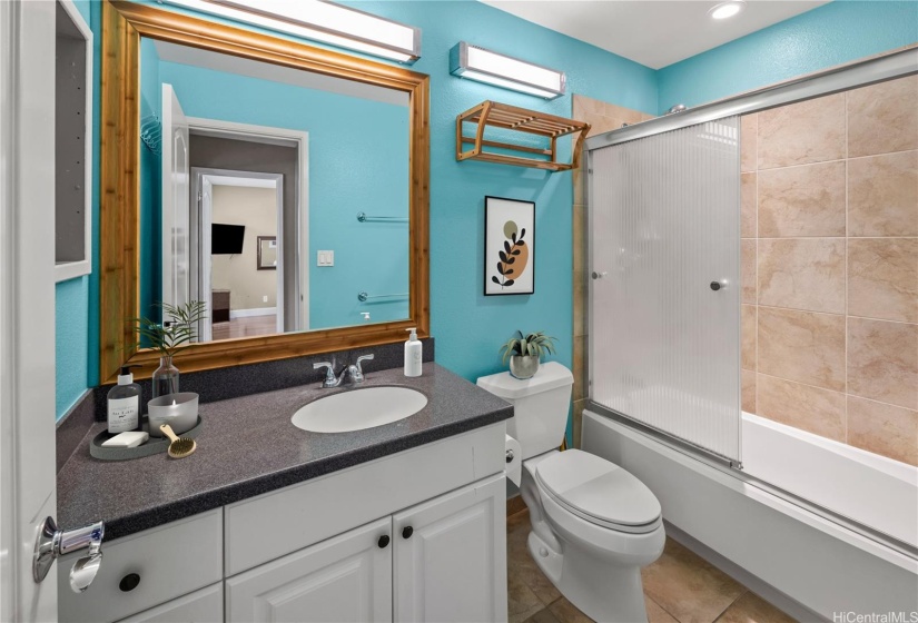 Guest bathroom with corian countertops and tiled floors