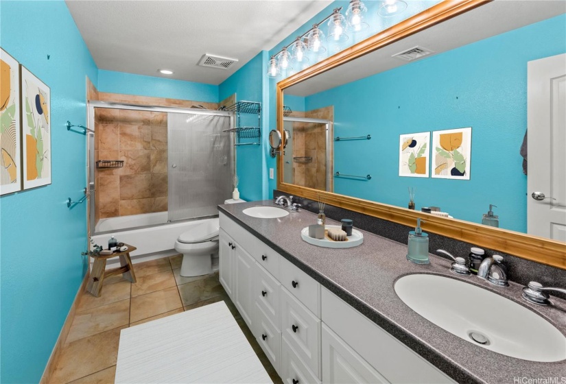 Primary bath has tiled floors, dual sinks and a soaking tub/shower.