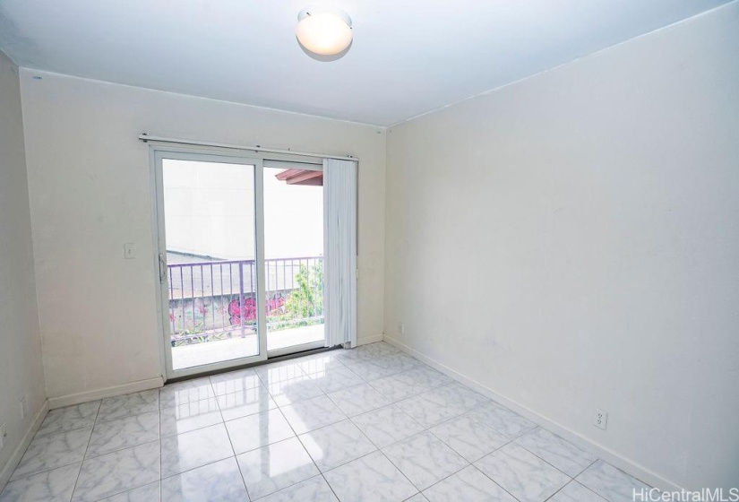 This is a typical interior bedroom with a balcony and tiled floors.