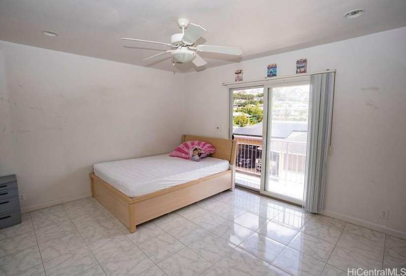 Master bedroom with private balcony and bath. The interior of the house features ceramic tile throughout the house.