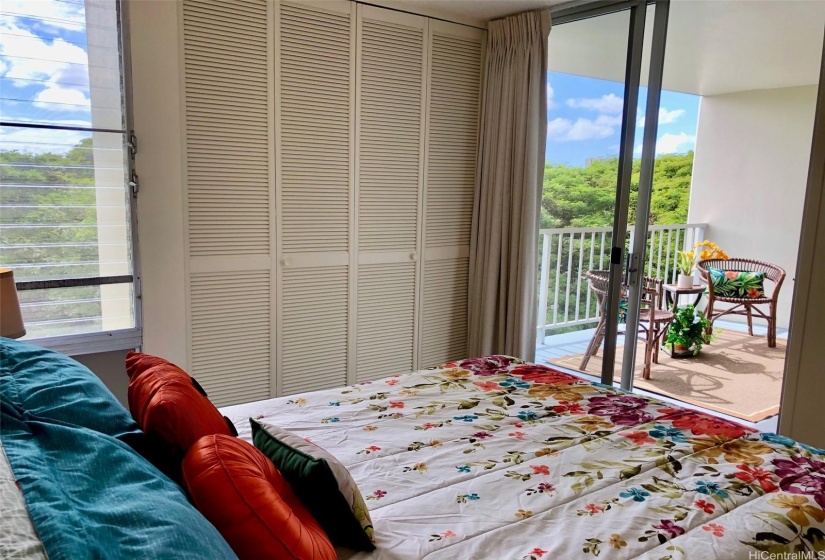 Bright and cheery bedroom has it's own sliding glass door to the lanai.