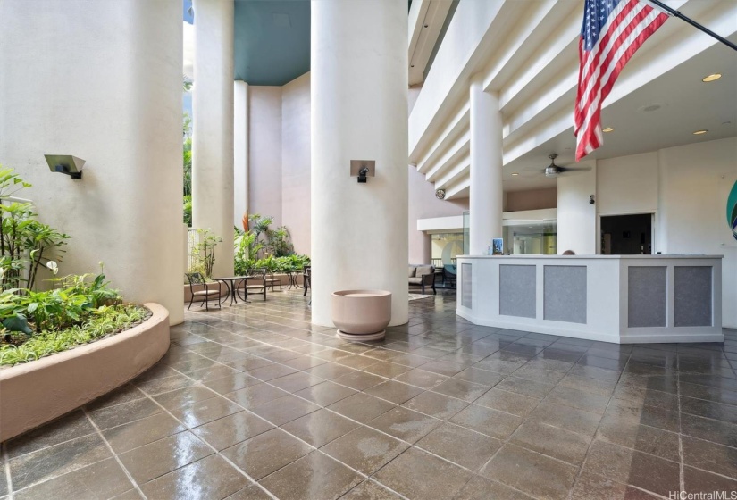 Spacious lobby with meeting area and security guard.