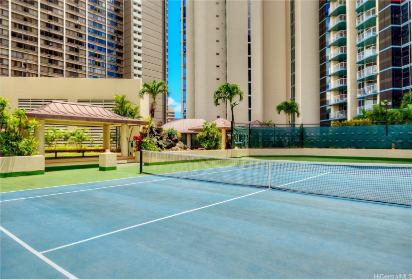 Tennis court with koi pond and pavilions in the background.