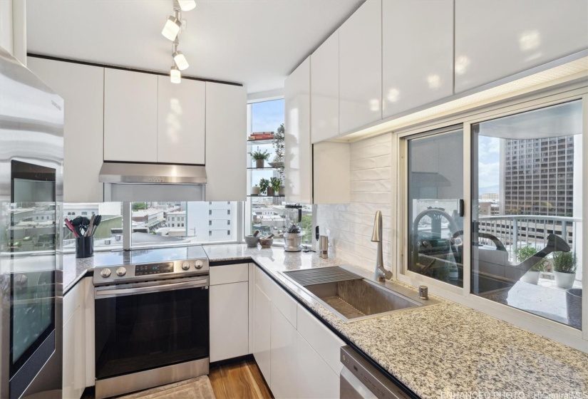 Spectacular views from stylish and functional kitchen, which was remodeled in 2022.  Photo has been digitally enhanced and staged.