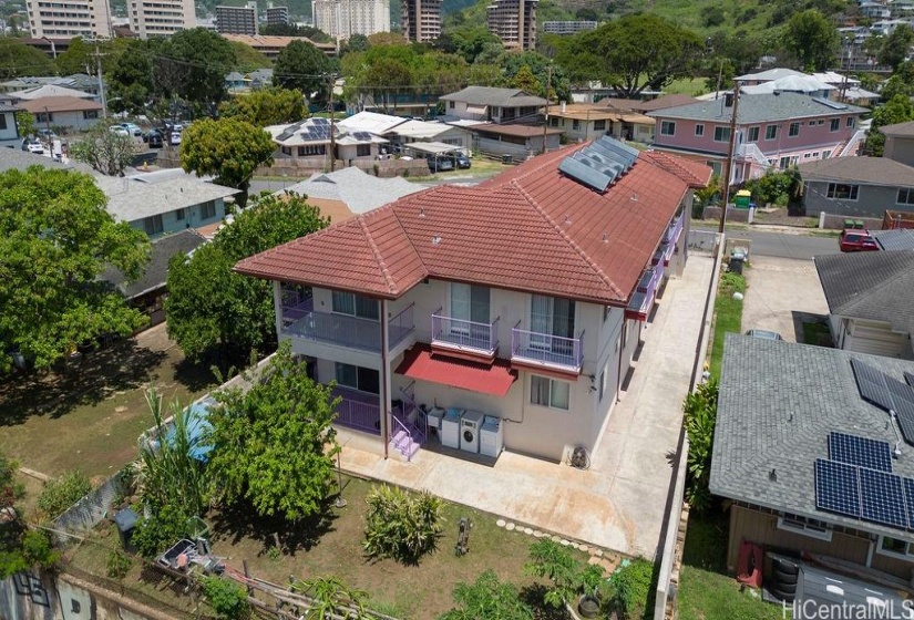 View of the property from Waialae Avenue. House has 3 solar water heaters and a coin operated laundry area.