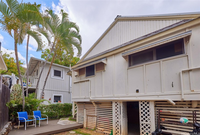 Back of house with small yard and extra storage