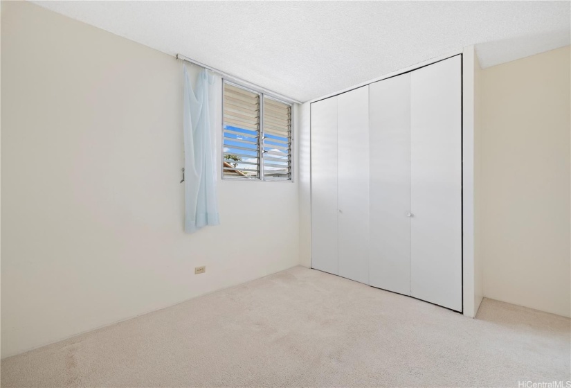 Another viewpoint of the secondary bedroom facing the built-in cabinets.