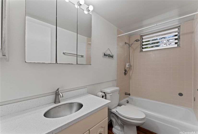 Full bathroom features updated counter top and faucet.