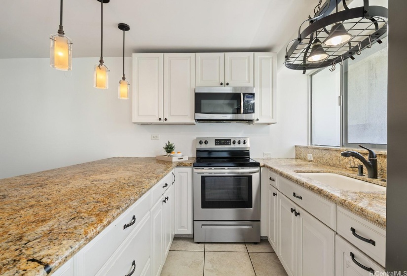 Plenty of cabinet and counter space in this updated island kitchen. The Stainless Steel Refrigerator stays.