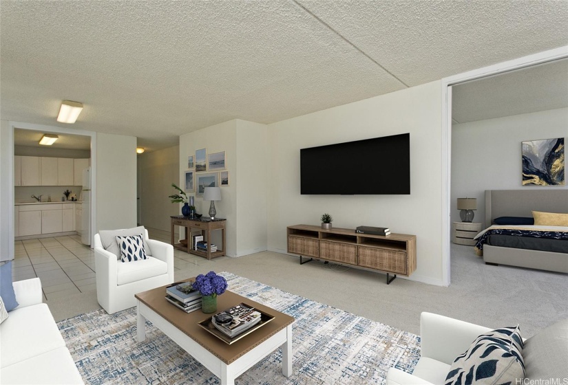 Virtually staged living room view from the lanai to the kitchen. Primary bedroom is on the right, separated by pocket sliding doors.