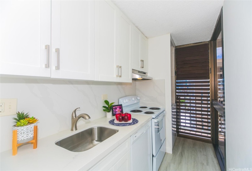 The modern kitchen tastefully renovated with white shaker cabinets and quartz countertops