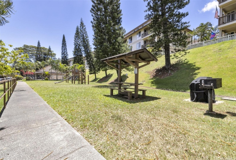 BBQ and playground area next to pool.