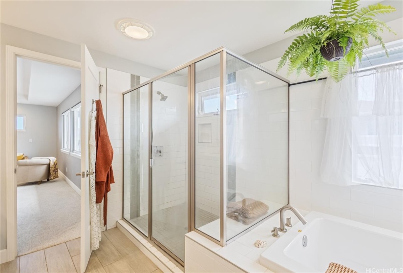 Primary suite boasts a large walk-in shower and soaker tub.