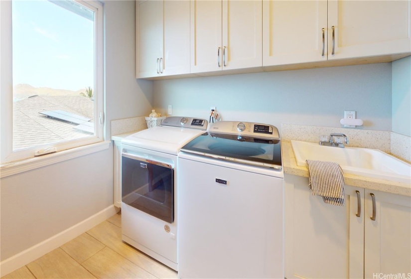 Laundry room conveniently located on upper level with cupboards, large sink and shelving not pictured.