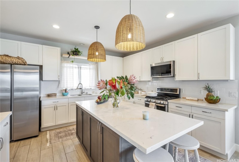 Kitchen has stainless appliances and island has added seating for dining.