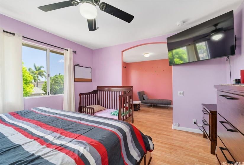 Primary bedroom showing extra alcove/living space in background.