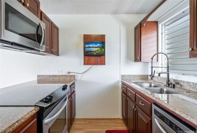 Kitchen equipped with refrigerator, microwave, hood, range, sink, and dishwasher