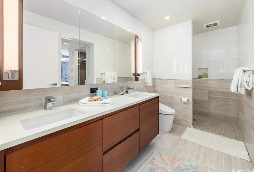 The gorgeous bathroom features double sinks, plenty of storage, and upgraded lighter 