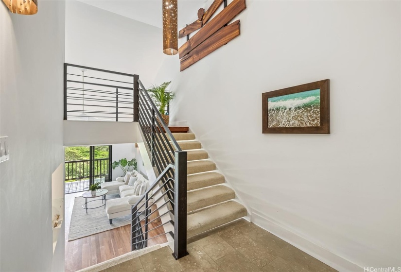 Welcoming entry foyer leads down to living area or up to primary bedroom